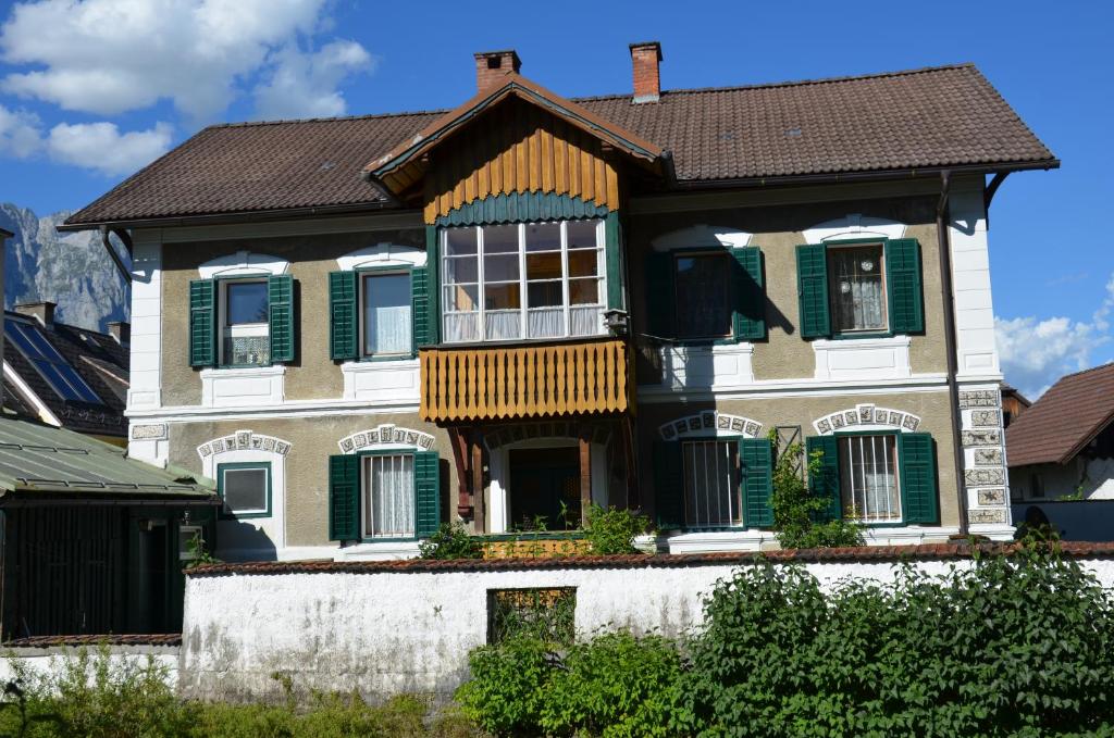 ein Haus mit grünen Rollläden und einem braunen Dach in der Unterkunft Haus Moser in Öblarn