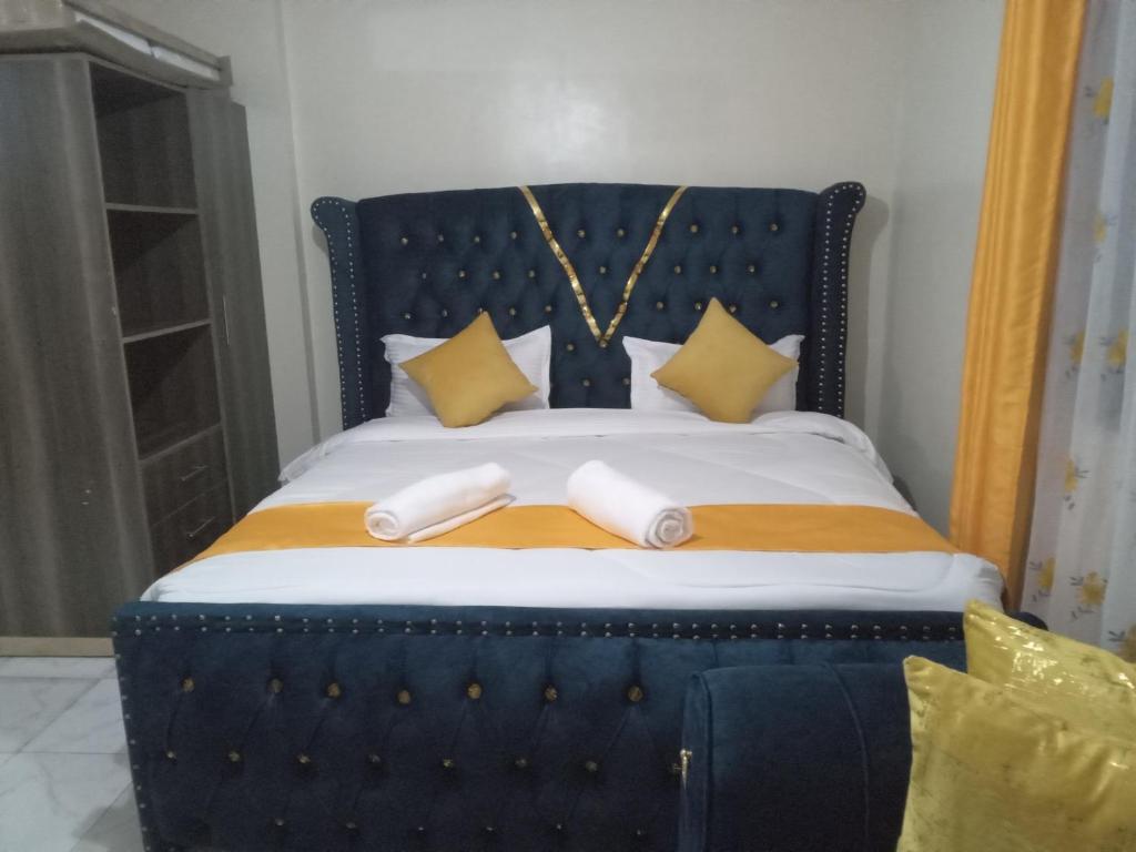 a blue bed with two white towels on it at Flomark in Ngong