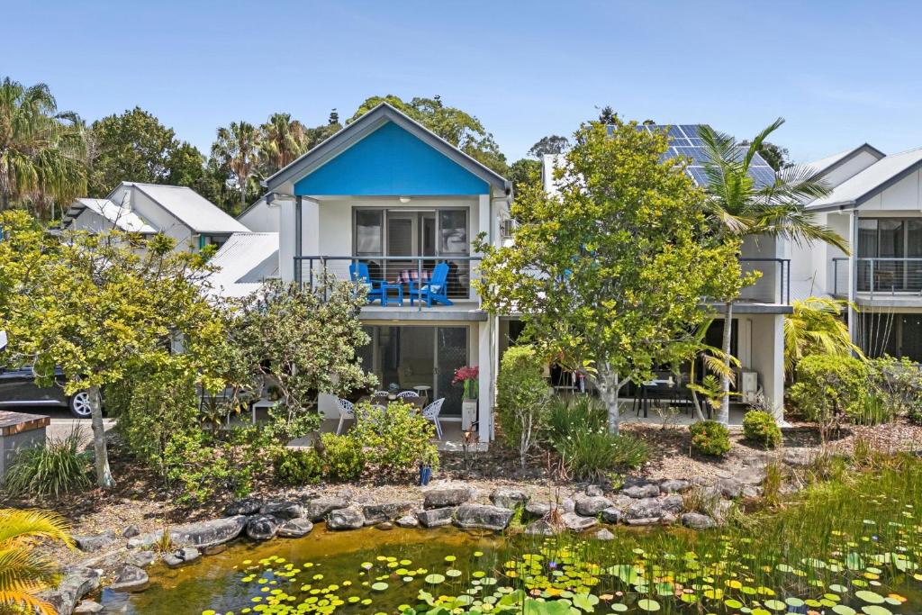 a house with a pond in front of it at Spacious, 2 bedroom Townhouse in Noosaville Resort in Noosaville