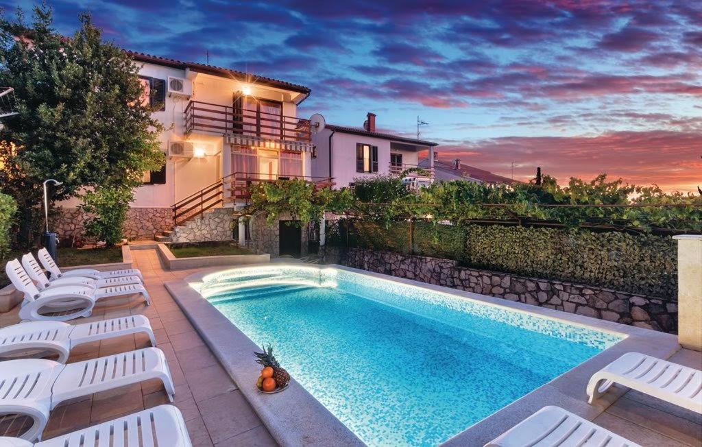 a swimming pool in front of a house at House Ivica in Banjole