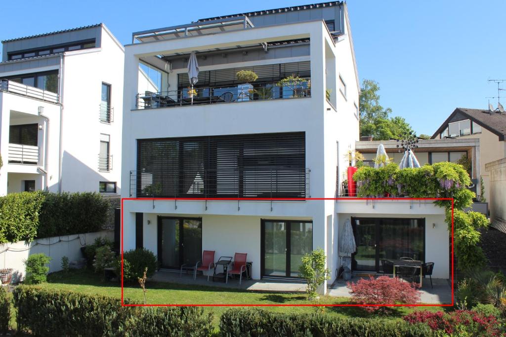a white house with a red line around it at Ferienwohnung Wellenreiter mit ruhigem Garten in Überlingen