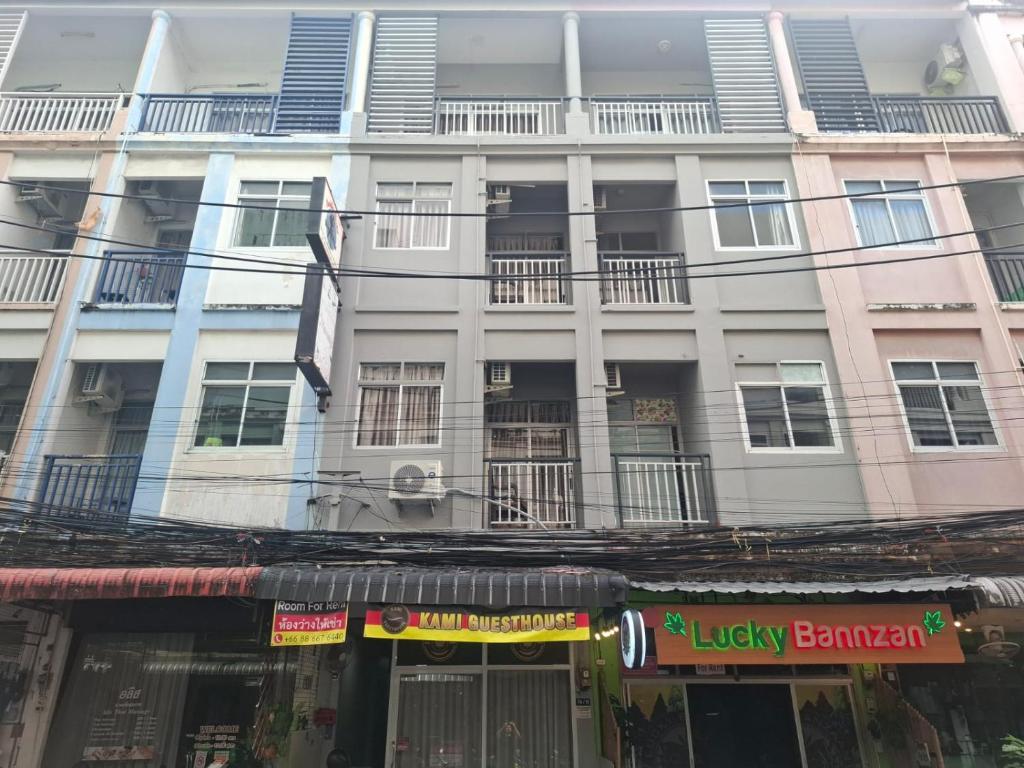 een groot wit gebouw met ramen en balkons bij Kami Guest House Patong in Patong Beach
