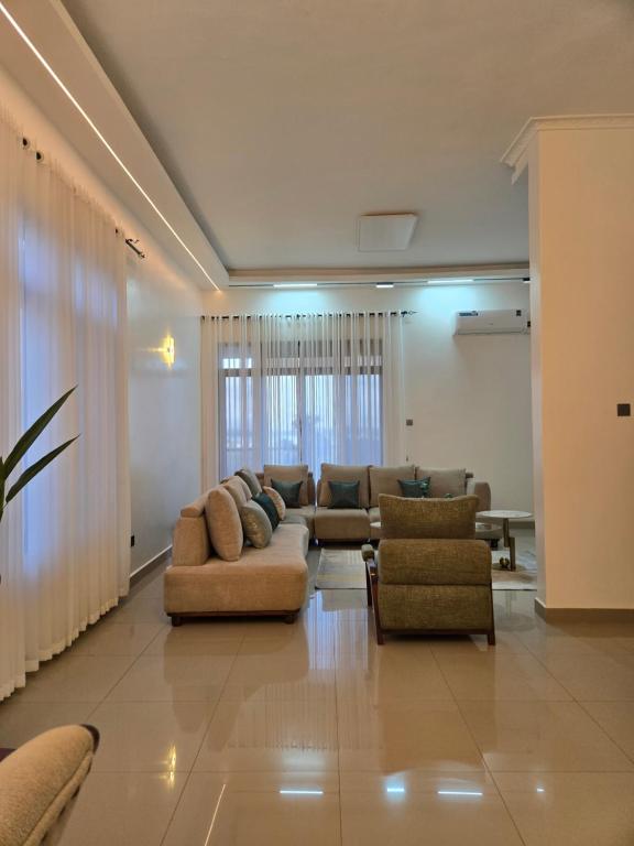 a large living room with couches and chairs at Matanak 2 in Munyonyo