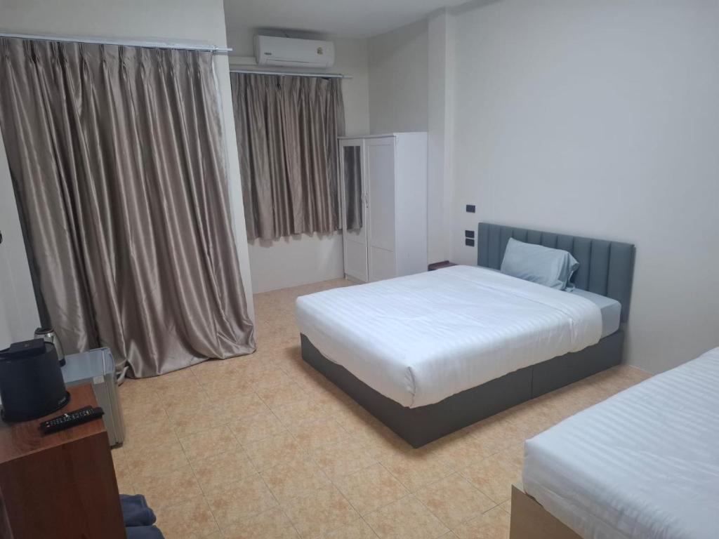 Een bed of bedden in een kamer bij Kami Guest House Patong