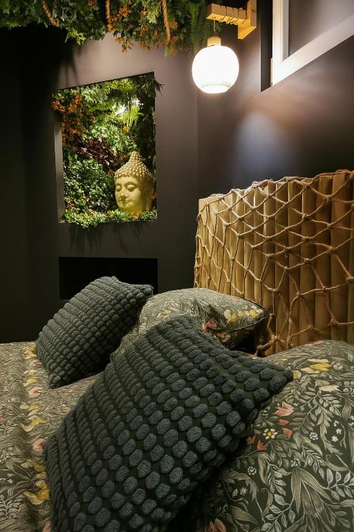 a bedroom with a bed with pillows and a picture on the wall at Jungle Room Strasbourg - Évasion Tropicale - Sauna Jacuzzi Balnéo in Strasbourg