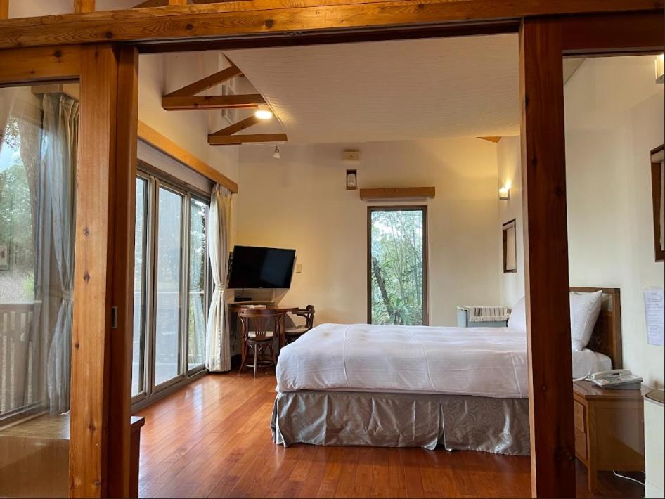 Un dormitorio con una cama y un escritorio con televisión. en 鳳凰森之鳴, en Lugu