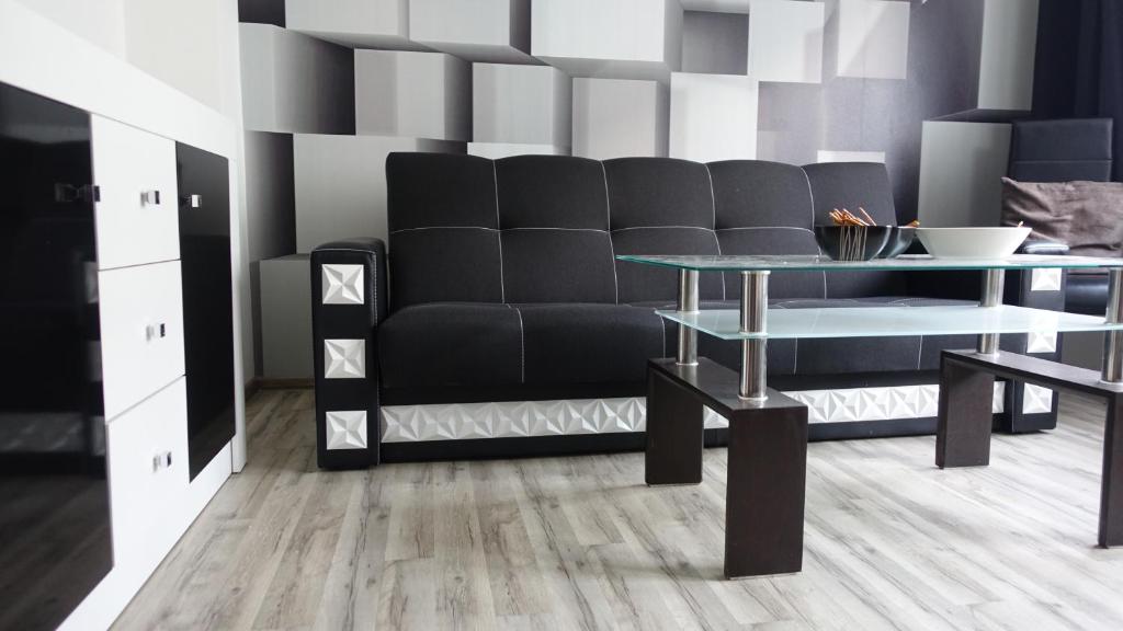 salon z czarną kanapą i stołem w obiekcie Apartament 3D w mieście Gdynia