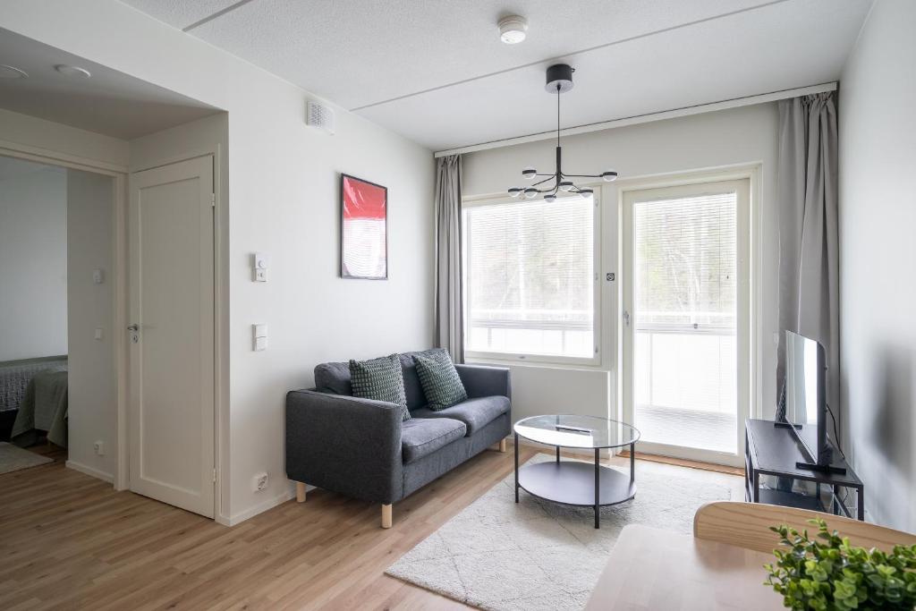 a living room with a couch and a table at Hiisi Homes Klaukkala in Klaukkala