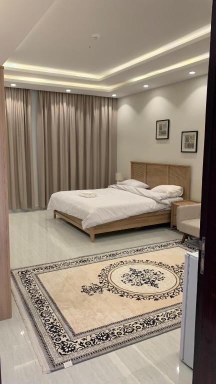 a bedroom with a large bed and a rug at دادن 1 - Dadan 1 in Al-ʿUla