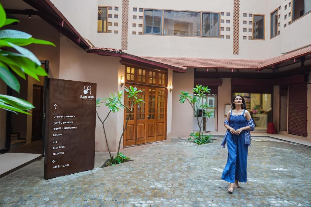 a woman in a blue dress standing in front of a building at Ekam Kashi in Varanasi