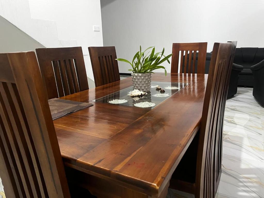 a wooden table with chairs and a potted plant at Villa Amore in Ahangama