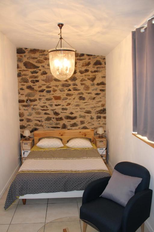une chambre avec un lit et un mur en pierre dans l'établissement L'HERMINE - pour 2 personnes, proche de la plage, à Binic