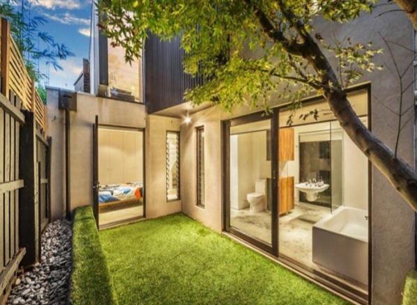 una casa con un patio con césped verde en Melbourne suites - Zen Oasis or skyline views, en Melbourne