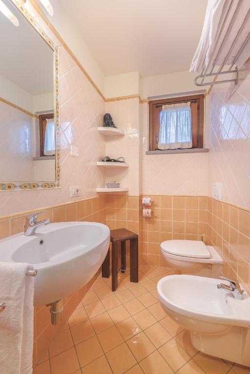 a bathroom with two sinks and a toilet at Sarzana-Charming Apartment Pool and BB in Sarzana