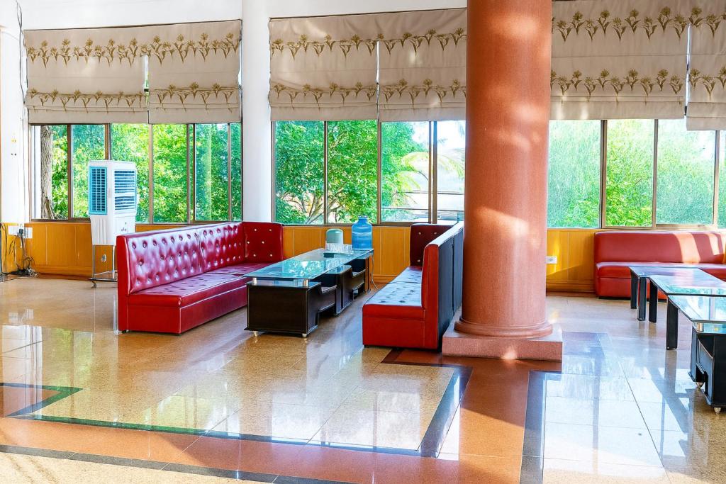 a lobby with a red couch and tables and windows at Viet Thai Hotel in Hồng Lĩnh