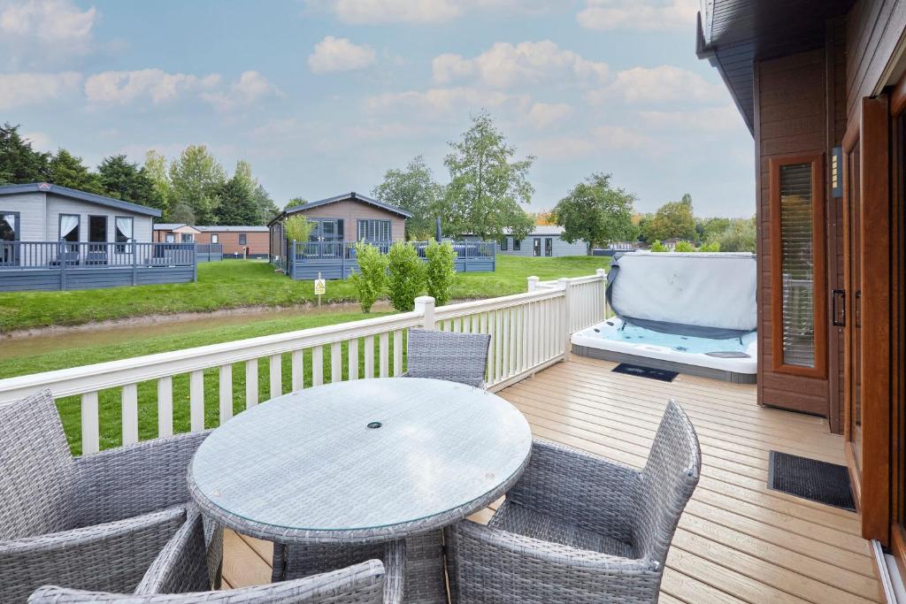 a patio with a table and chairs on a deck at Kinship Lodge with Hot Tub in York