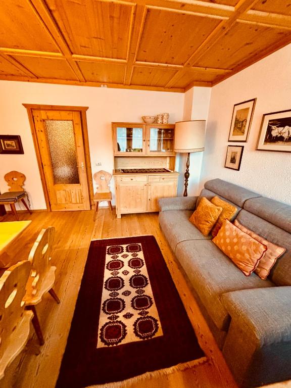 a living room with a couch and a table at Apartament Loft Fiemme in Castello di Fiemme