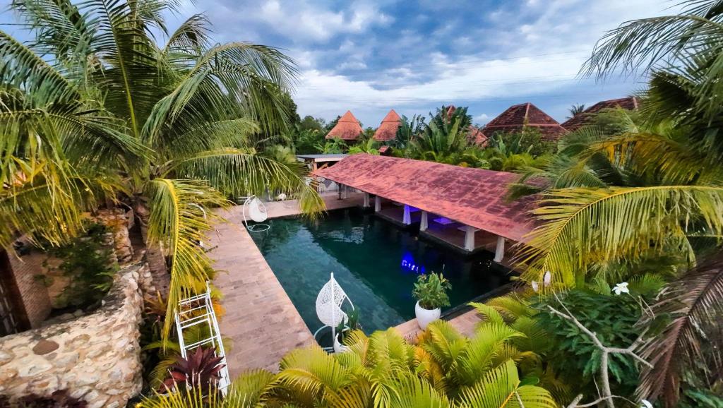 een luchtzicht op een resort met een zwembad en palmbomen bij Villa Sultan in Kampot