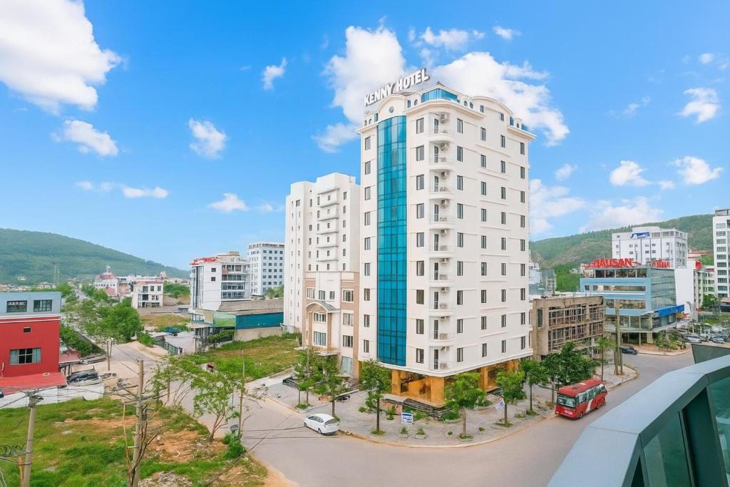 a tall white building in a city at Kenny Hotel Ha Long in Ha Long