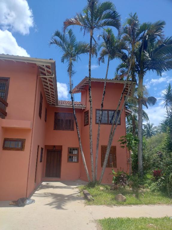 une maison avec des palmiers devant dans l'établissement Suite na mansão Ilhabela, à Ilhabela