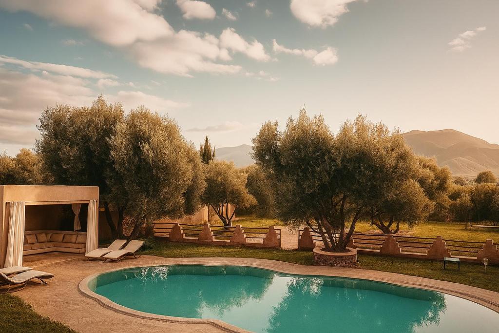 a swimming pool in a yard with trees at EdenAtlas Chambres d'hôtes - Amizmiz in Amizmiz