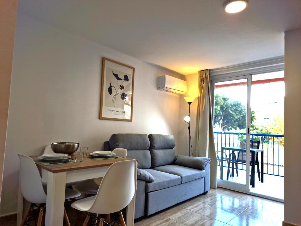 a living room with a couch and a table at APCOSTAS Palmavera Playa de la Conxa in Oropesa del Mar