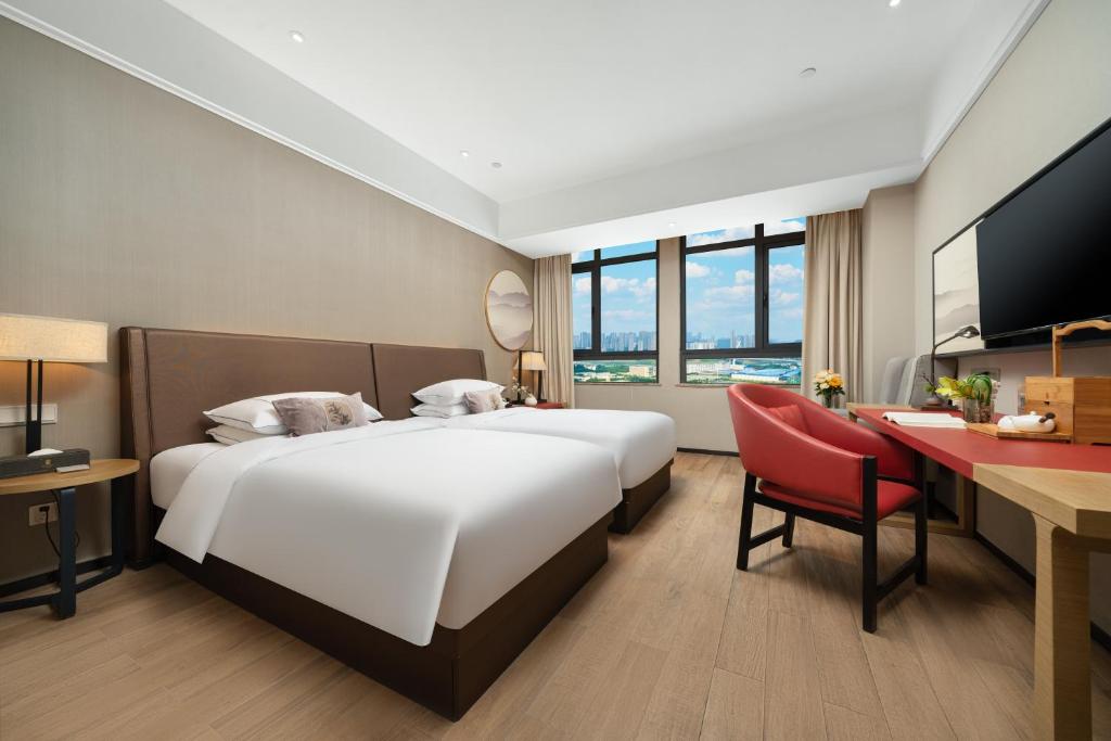 Postel nebo postele na pokoji v ubytování 南宁江南万达白沙大道怡程酒店
