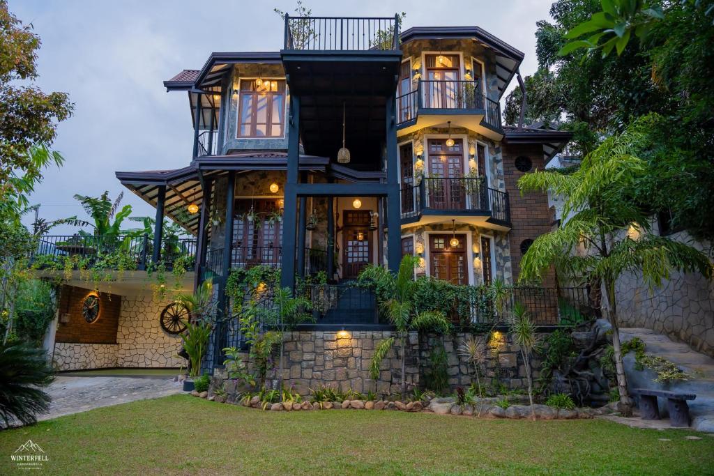 a large house with a stone wall at Winterfell Bandarawela in Bandarawela