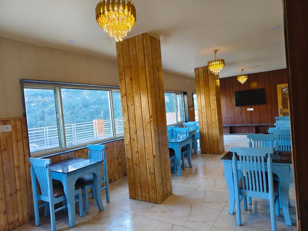 a dining room with blue tables and blue chairs at Green View in Mussoorie