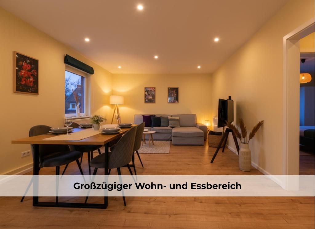 comedor y sala de estar con mesa y sofá en Utes Huus, en Wyk auf Föhr