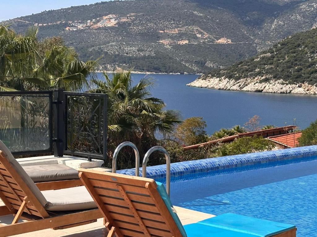 einen Pool mit Stühlen und Seeblick in der Unterkunft Marvelous Seaview Villa Lemon Kalkan in Kalkan
