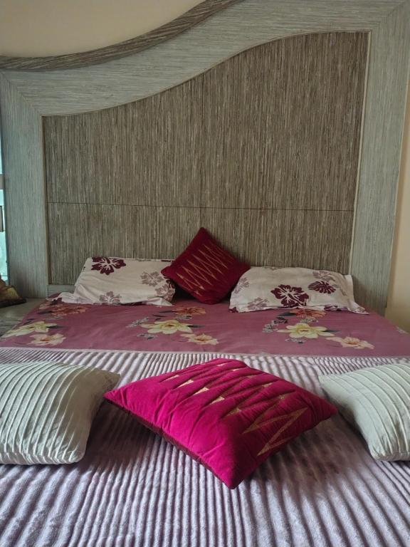 埃尔加德Hotel Happy Hill的一张大床,上面有粉红色和白色的床单