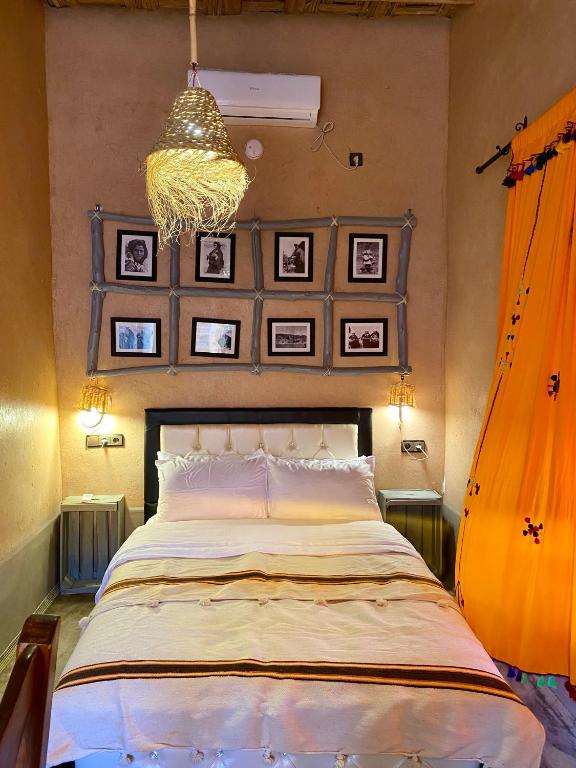 a bedroom with a large bed and a chandelier at Nomadic Birdway in Imiter