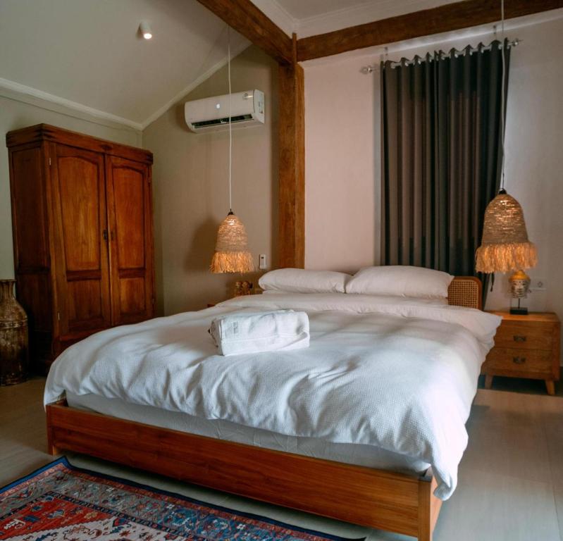 a bedroom with a large bed with two lamps at Villa Soluna Lovina in Lovina