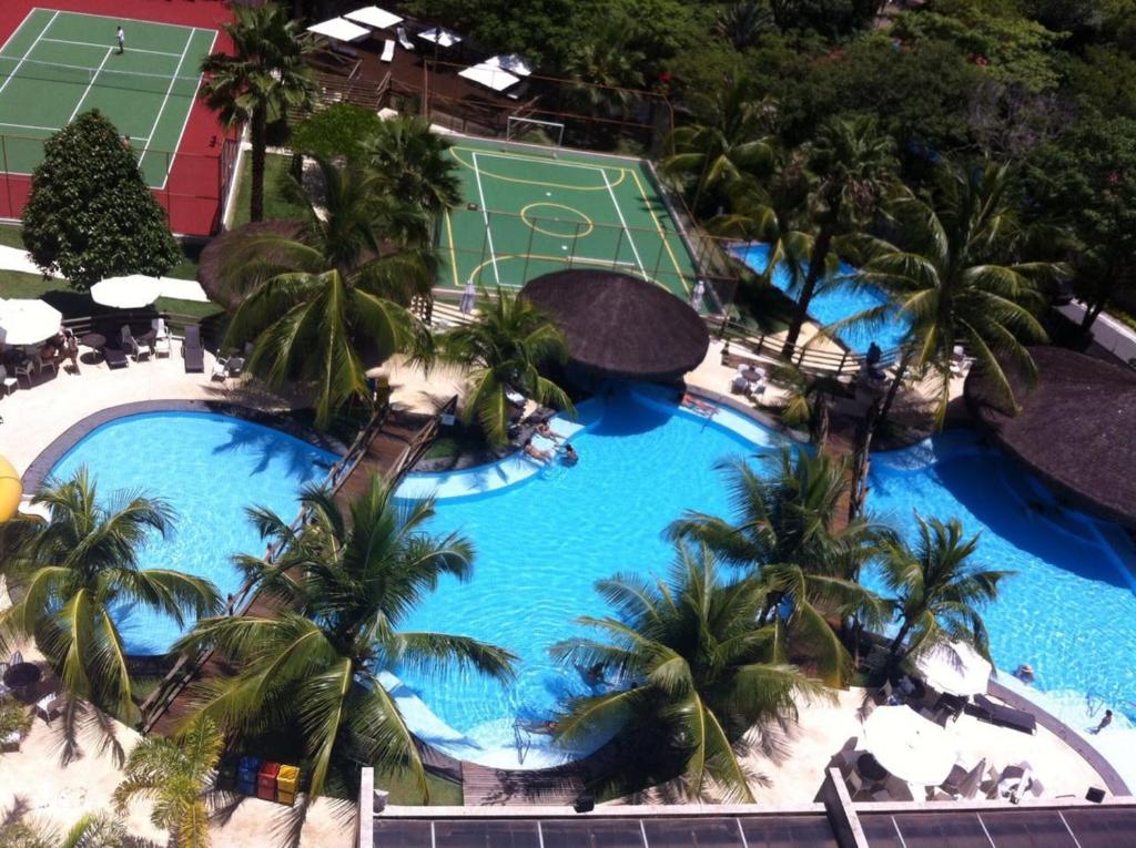 een uitzicht over een zwembad met een tennisbaan bij Suites Le Jardin - Caldas Novas in Caldas Novas