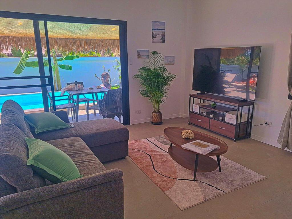 a living room with a couch and a tv at Villa l'Aurora in Amphoe Koh Samui