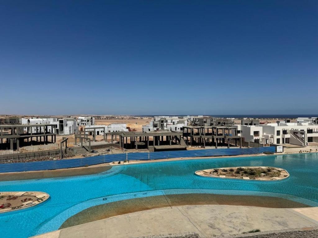 a view of a large swimming pool with buildings in the background at 3 bedrooms penthouse with sea view in Hurghada