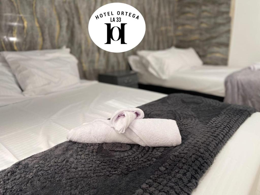 une chambre d'hôtel avec une serviette sur un lit dans l'établissement hotel ortega la 33, à Medellín