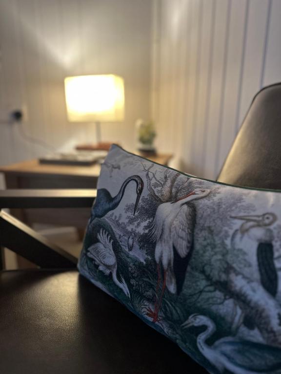 a chair with a pillow with a picture of a bird at The Stables & Silos in Braintree