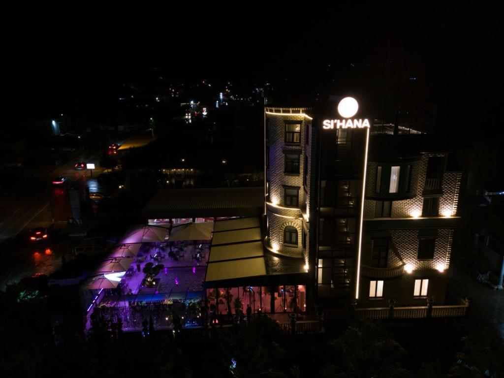 Una vista nocturna de un edificio con un letrero iluminado. en Si'Hana Hotel, en Elbasan