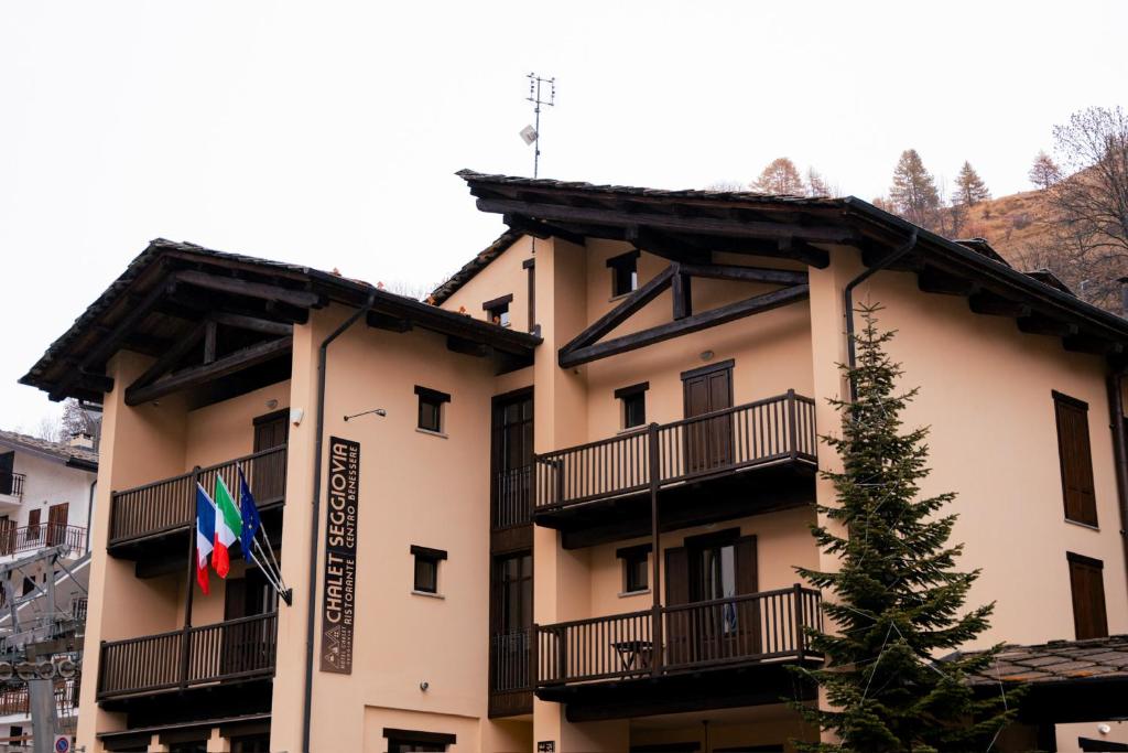 a building with a flag on the side of it at Hotel Chalet Seggiovia in Pontechianale