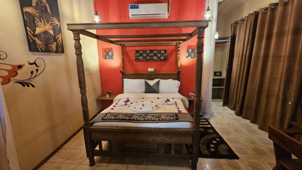 ein Schlafzimmer mit einem Bett mit einem hölzernen Baldachin in der Unterkunft Maridadi Plaza Apartment in Jambiani