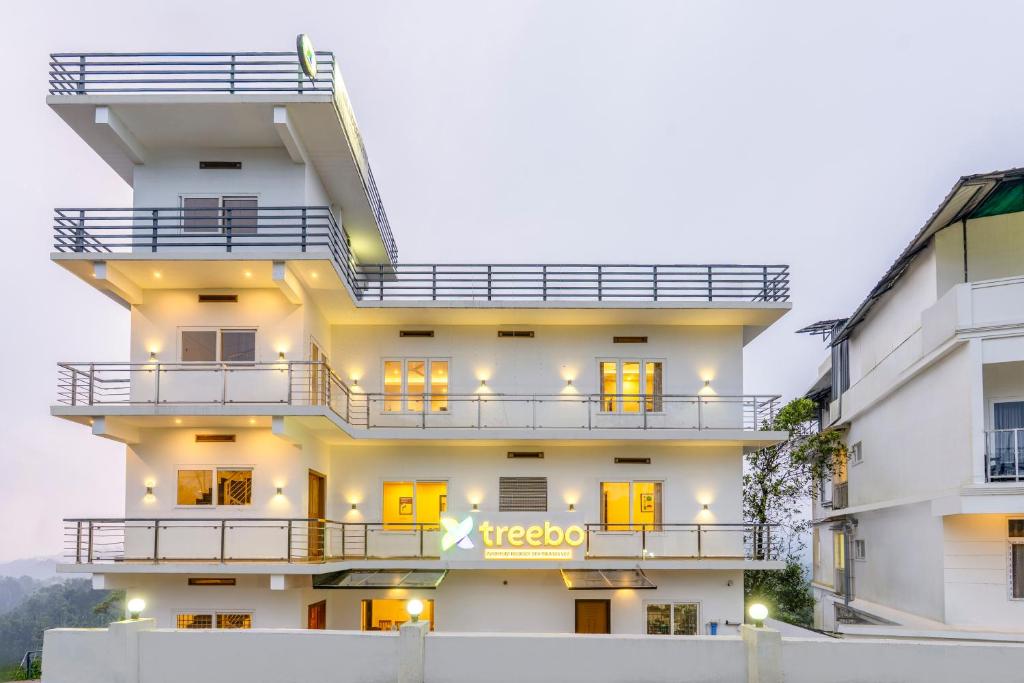 a white building with a sign on it at Treebo Wanderlust Residency With Mountain View in Munnar