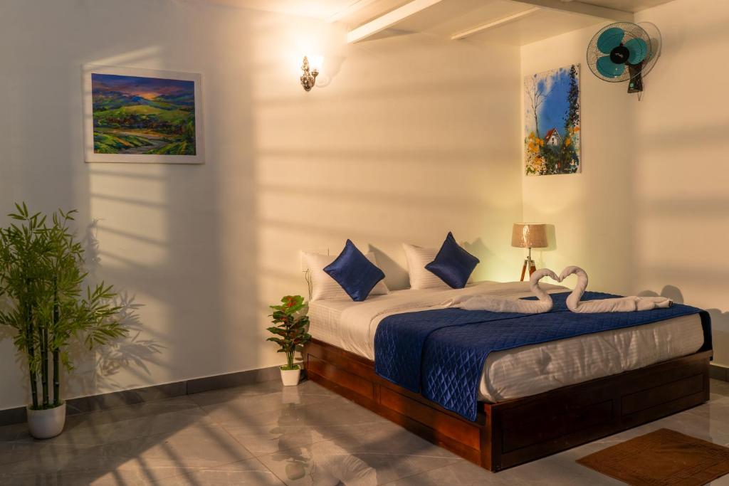 a bedroom with a bed with blue sheets and pillows at Coorg Saturn Homes in Madikeri