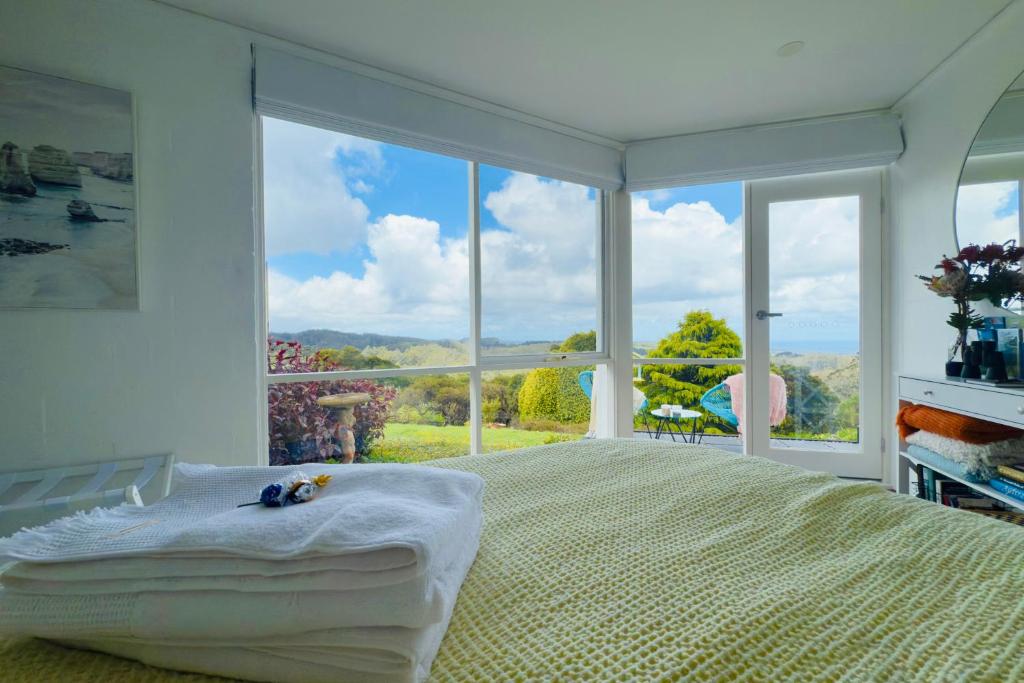 Un dormitorio con una cama grande y una ventana grande en Southern Heights, en Lavers Hill