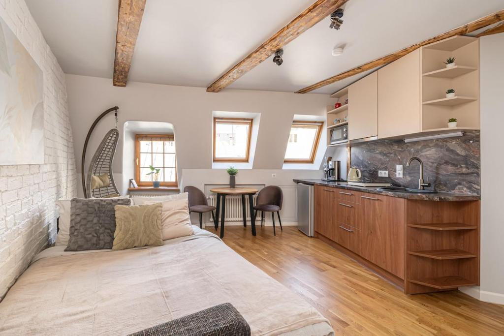 a kitchen and living room with a bed and a table at Old Town Gem - Rooftop Studio - By Innorental in Rīga