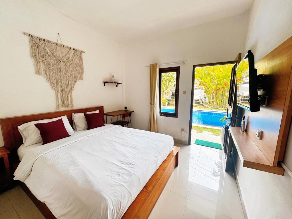 une chambre avec un lit, une télévision et une fenêtre dans l'établissement GreatiStay Living&Working Canggu, à Tumbak Bayuh