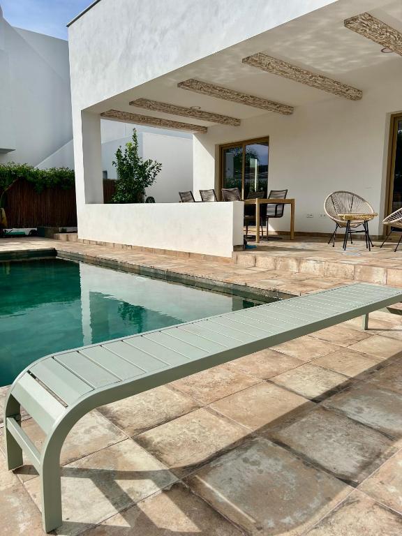 a swimming pool with a bench in front of a house at Casa Milivan Spacious Family Villa with Private Pool in Las Villas