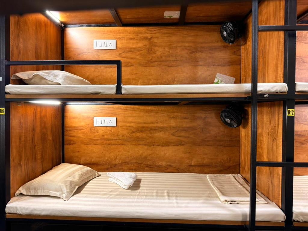 a room with three bunk beds in it at Hans Dormitory in Mumbai