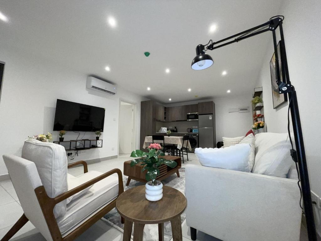 阿克拉The Bantree D-plus Apartments的客厅里有一张沙发和一张桌子。